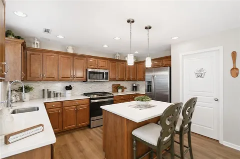 a kitchen with refrigerator a sink and chairs