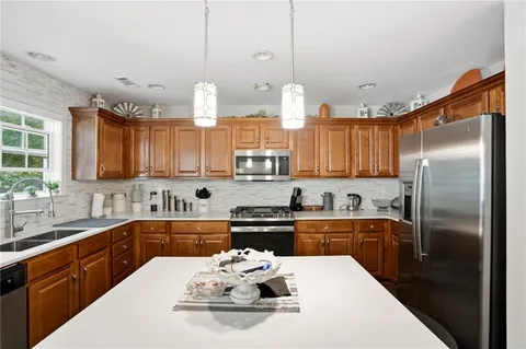 a kitchen with granite countertop a sink cabinets and stainless steel appliances
