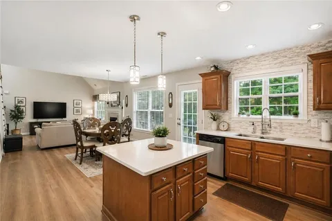 a kitchen with sink a counter and chairs