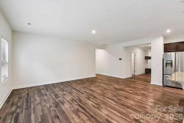 a view of empty room with wooden floor and window