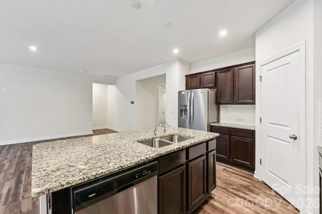 a kitchen with stainless steel appliances granite countertop a sink stove and refrigerator