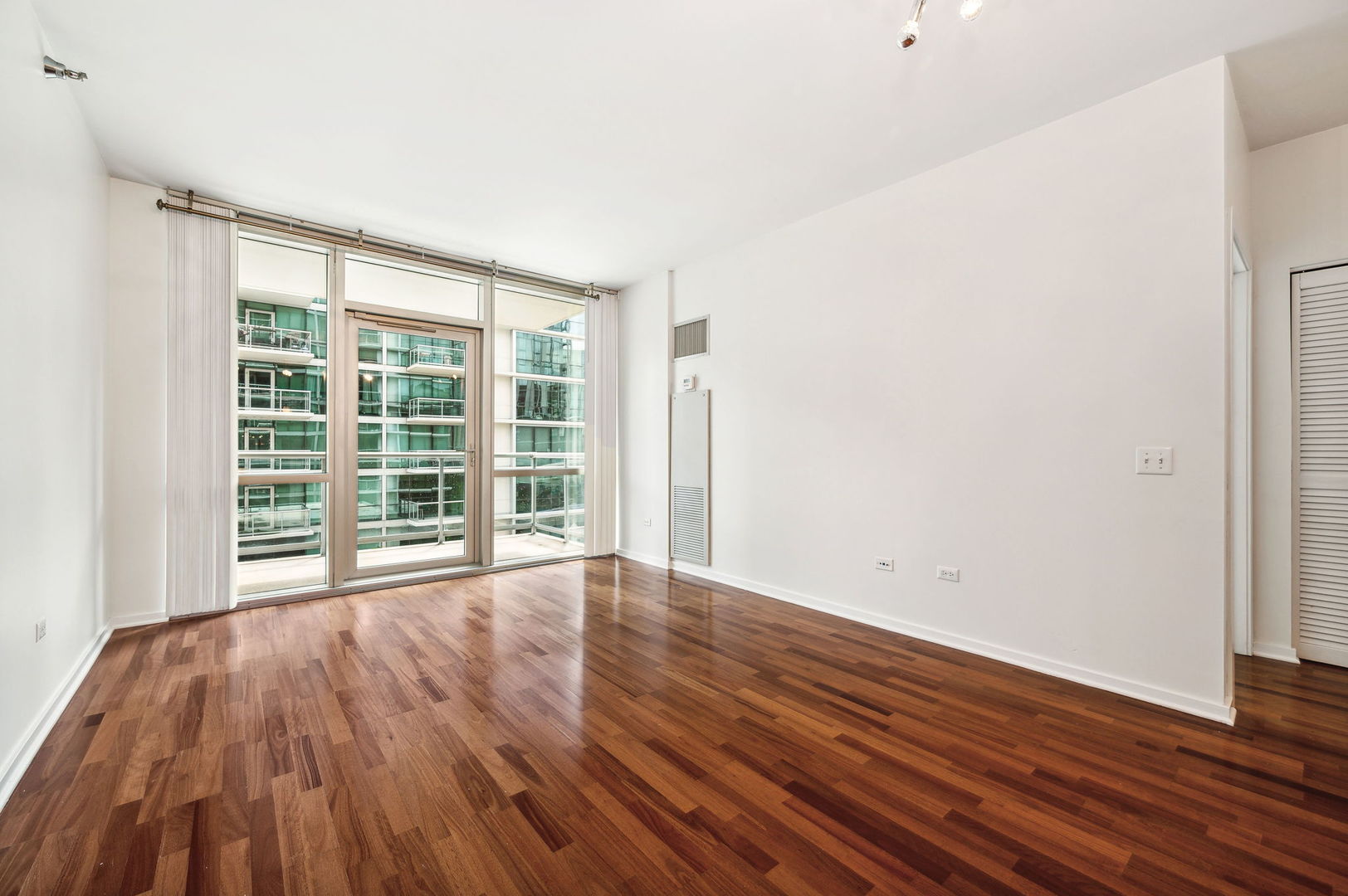 123 South Green Street, Unit 407B Chicago, IL 60607 - Photo 5 of 20 a view of an empty room with wooden floor and a window