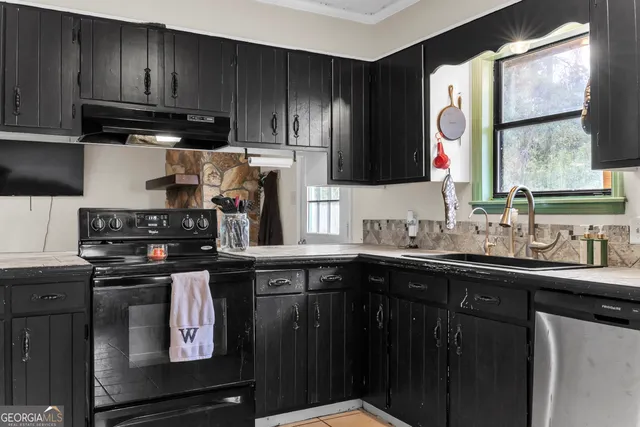 a kitchen with stainless steel appliances granite countertop a sink stove and cabinets