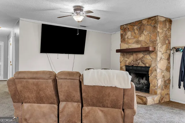 a living room with furniture a flat screen tv and a fireplace