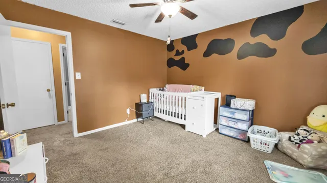 a room with a baby bed furniture and a window