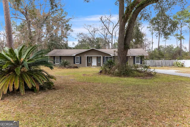 a front view of house with yard and trees