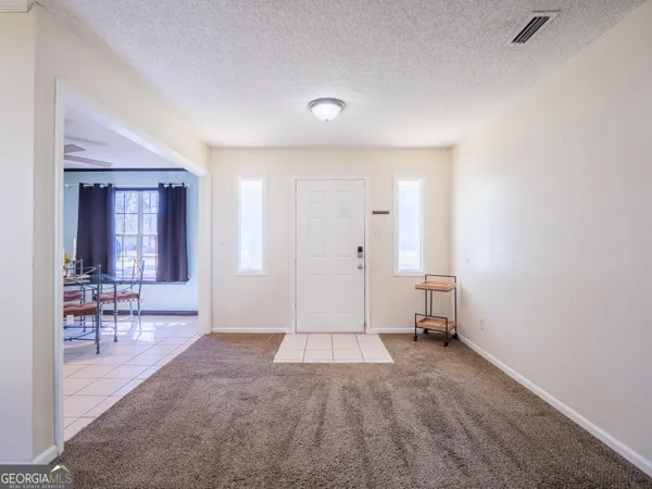 a front view of house with yard and trees in the background