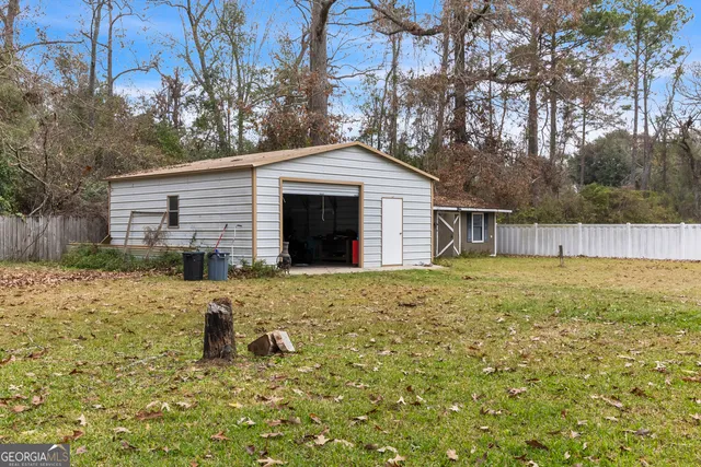 a front view of house with yard and trees in the background