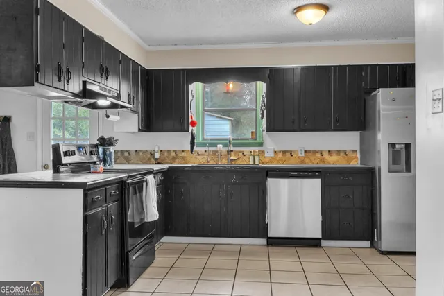 a kitchen with stainless steel appliances granite countertop a refrigerator and a stove