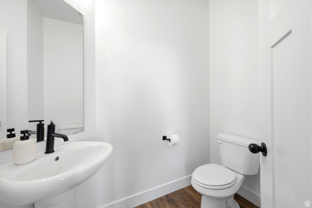 4646 Alder Drive, Unit 223 Mapleton, UT 84664 - Photo 10 of 35 Bathroom featuring a pedestal sink with a matte black faucet, a toilet with a matte black handle, and wood-finish flooring