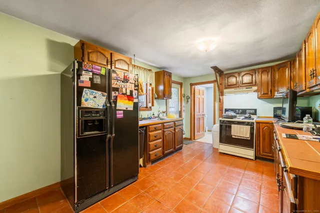 a kitchen with stainless steel appliances granite countertop a refrigerator and a stove top oven