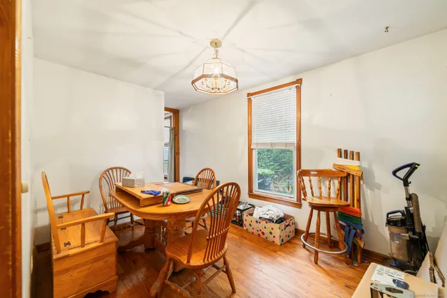 a dining room with furniture a chandelier and wooden floor