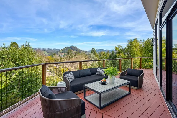 a view of a roof deck with couches and wooden floor
