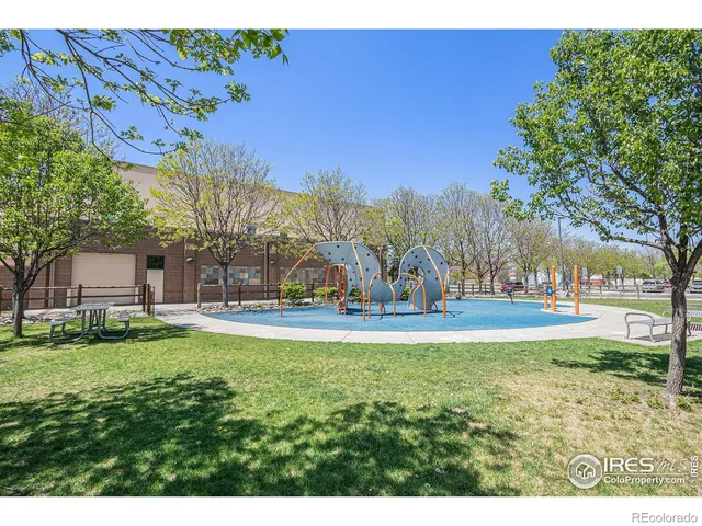 a view of swimming pool with outdoor seating and trees in the background