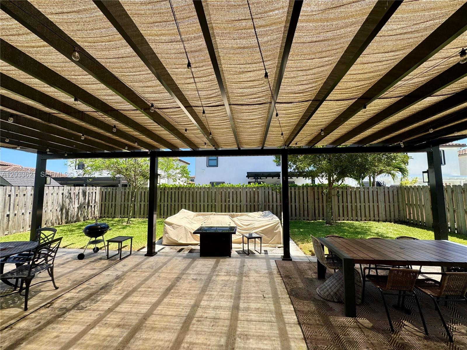 11942 Southwest 243rd Street Homestead, FL 33032 - Photo 37 of 50 a view of a patio with table and chairs potted plants with wooden floor and roof