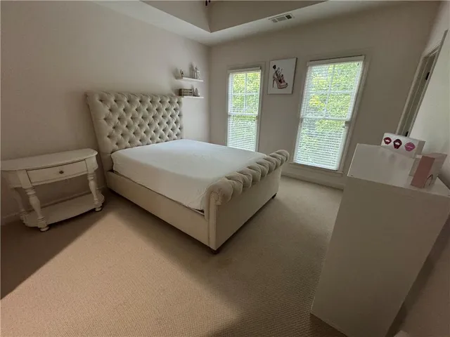 a bed sitting in a bedroom next to a window