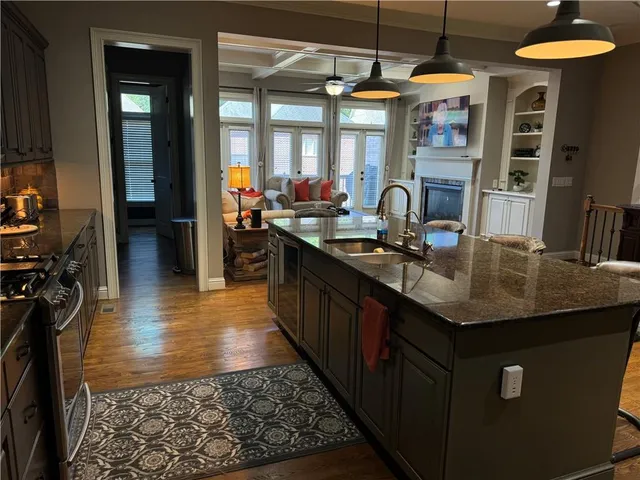 a kitchen with stainless steel appliances granite countertop a sink and a stove