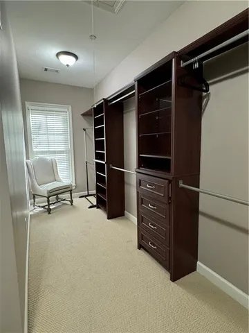 a view of an empty room with furniture and a window