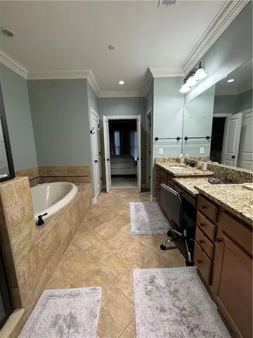 a spacious bathroom with a tub sink and mirror
