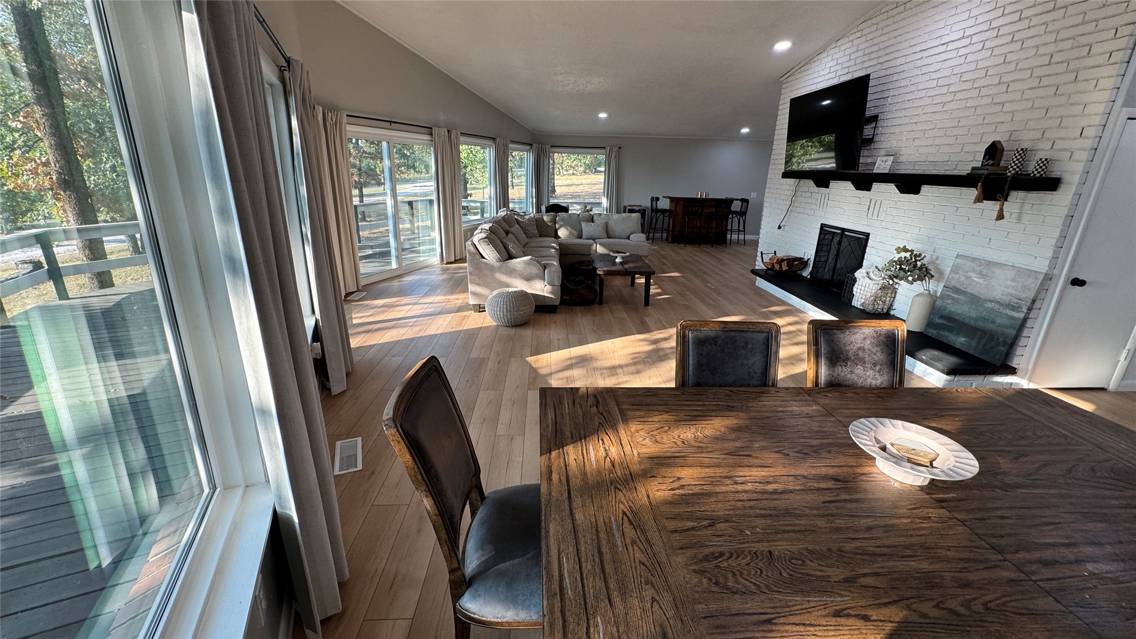 96358 South 4531 Road Vian, OK 74962 - Photo 4 of 58 Open-concept living space featuring wood-finish flooring, a white brick fireplace with a black hearth, and a vaulted ceiling with recessed lighting
