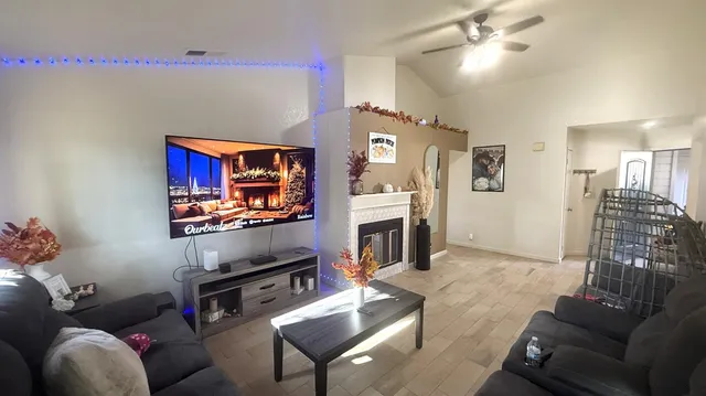 a living room with furniture a flat screen tv and a fireplace