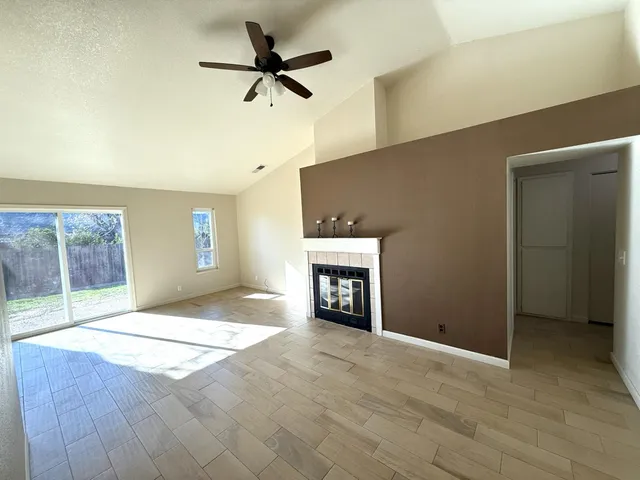 an empty room with windows and fireplace