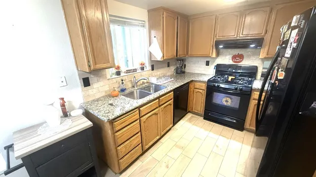 a kitchen with stainless steel appliances granite countertop a sink stove and refrigerator