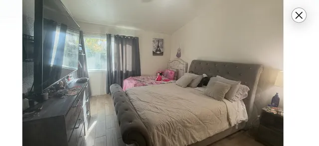 a bed sitting in a bedroom next to a window