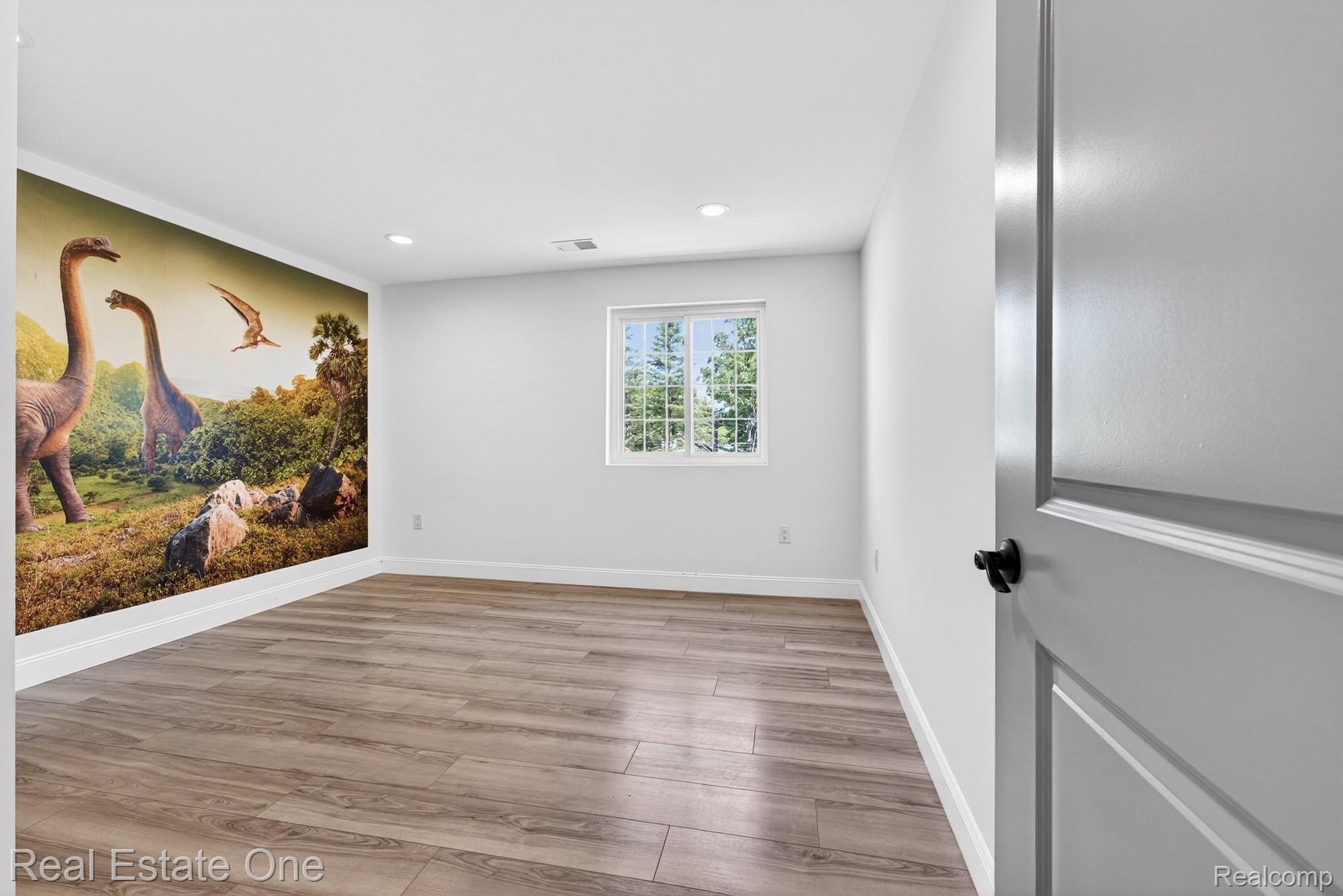 26987 Crawford Road Romulus, MI 48174 - Photo 29 of 51 Spacious room featuring wood-finish flooring, a wall mural, recessed lighting, and a window with natural light