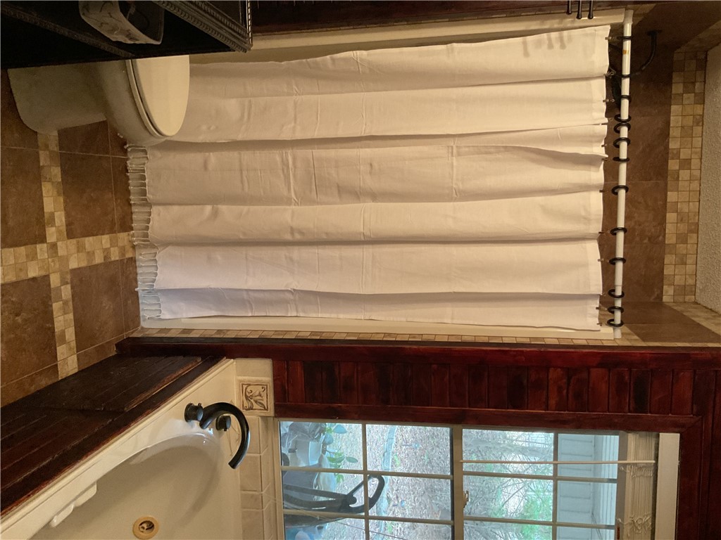 229 Cub Cove Drive Walhalla, SC 29691 - Photo 27 of 50 This bright bathroom features a spacious tub and shower, with a window offering serene outdoor views.