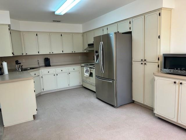 17403 Southwest 27 Ct Road Ocala, FL 34473 - Photo 36 of 47 a kitchen with stainless steel appliances a refrigerator sink and cabinets