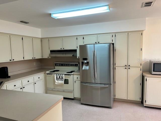 17403 Southwest 27 Ct Road Ocala, FL 34473 - Photo 37 of 47 a kitchen with stainless steel appliances a refrigerator stove and white cabinets