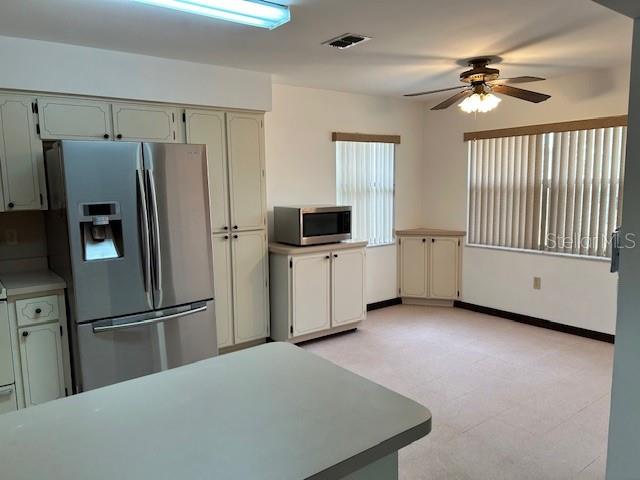 17403 Southwest 27 Ct Road Ocala, FL 34473 - Photo 38 of 47 a view of a kitchen with refrigerator cabinets and a ceiling fan