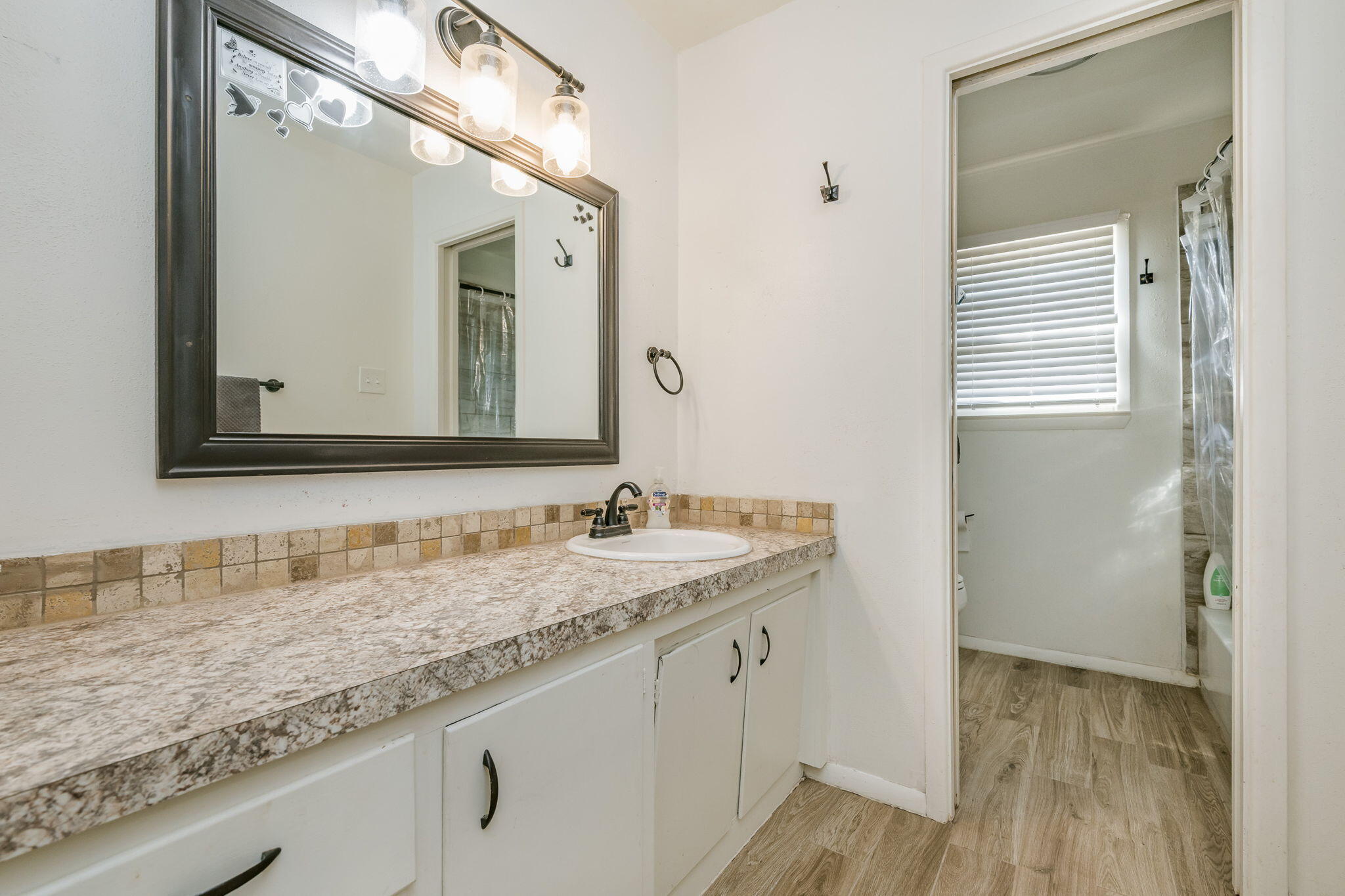 1723 County Road 9 Tulia, TX 79088 - Photo 13 of 32 a bathroom with a granite countertop sink and a mirror