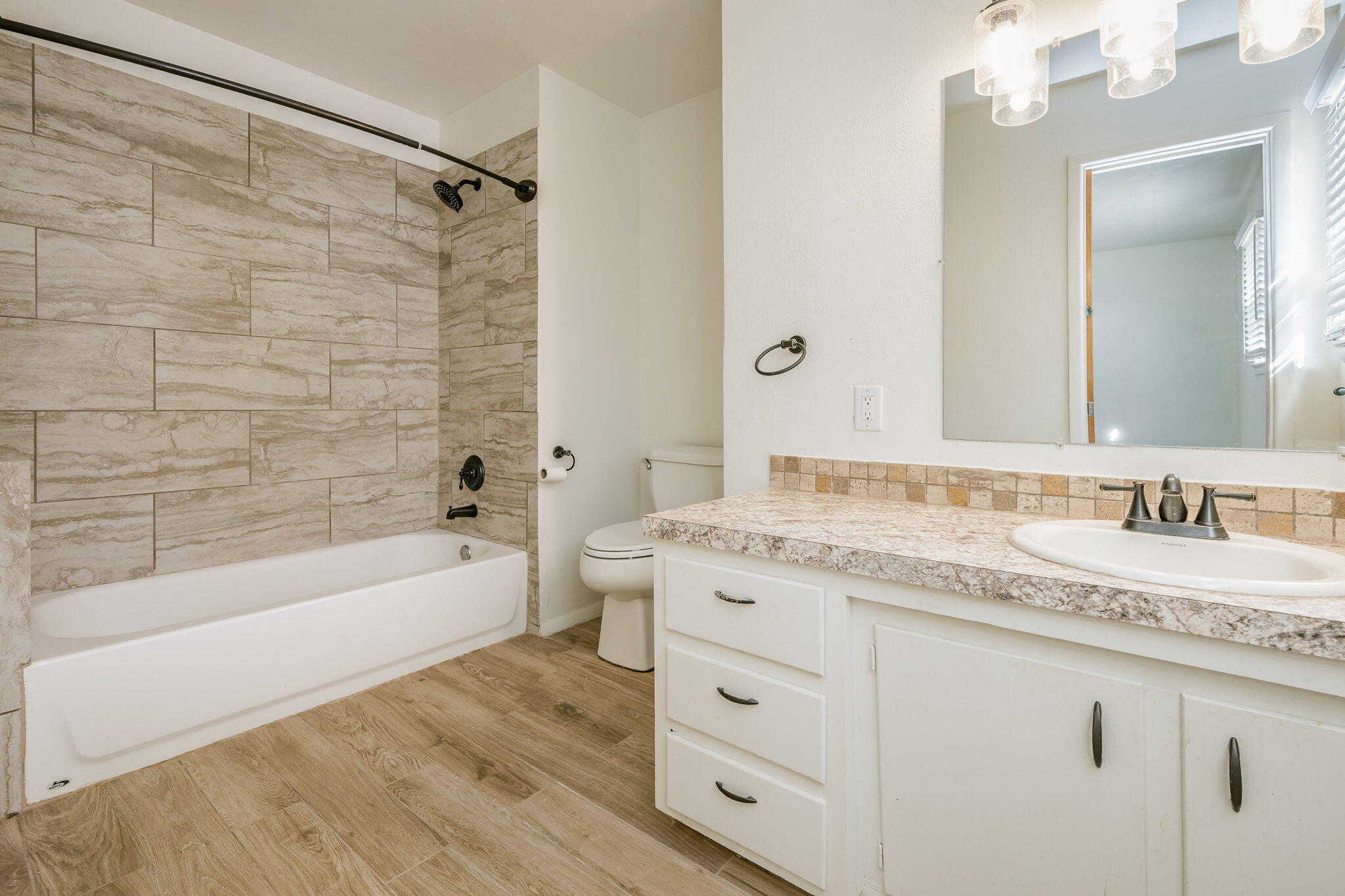 1723 County Road 9 Tulia, TX 79088 - Photo 19 of 32 a bathroom with a granite countertop sink mirror toilet and bathtub