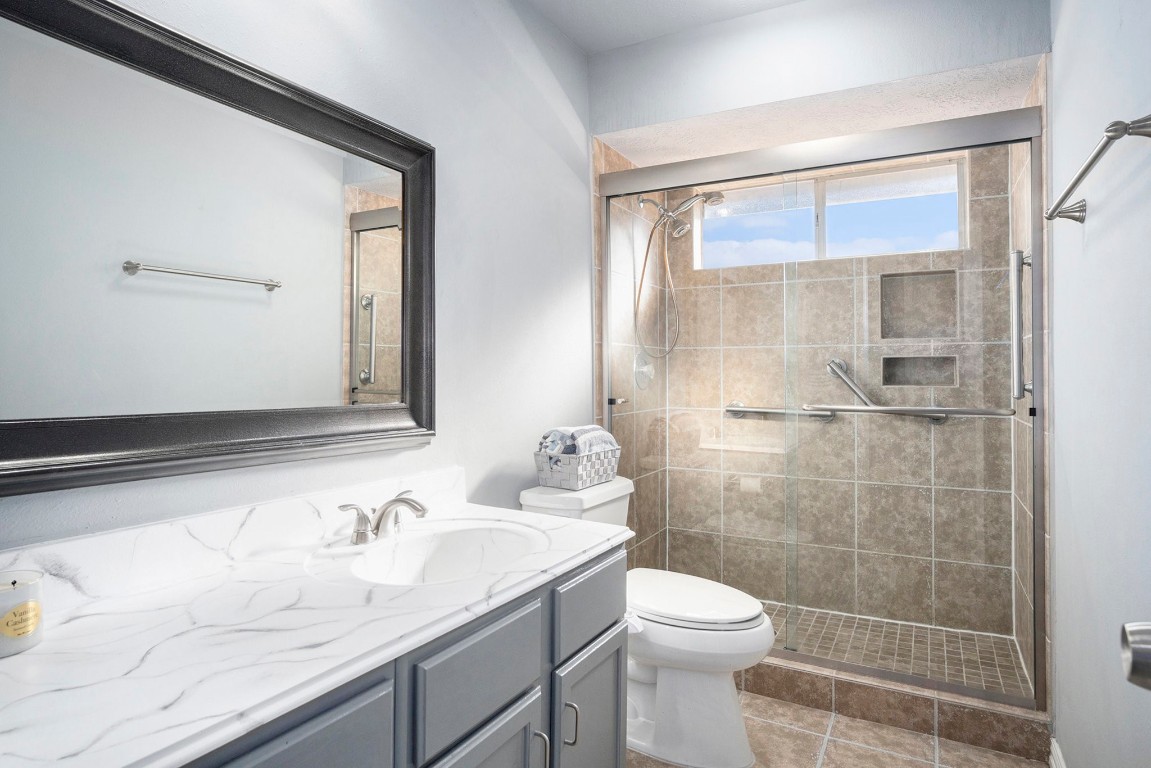 3315 Mourning Dove Drive Spring, TX 77388 - Photo 38 of 44 a bathroom with a granite countertop sink a toilet and a mirror