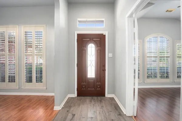 an empty room with wooden floor and a window