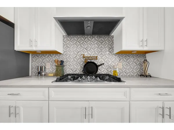 a kitchen with white cabinets and a stove