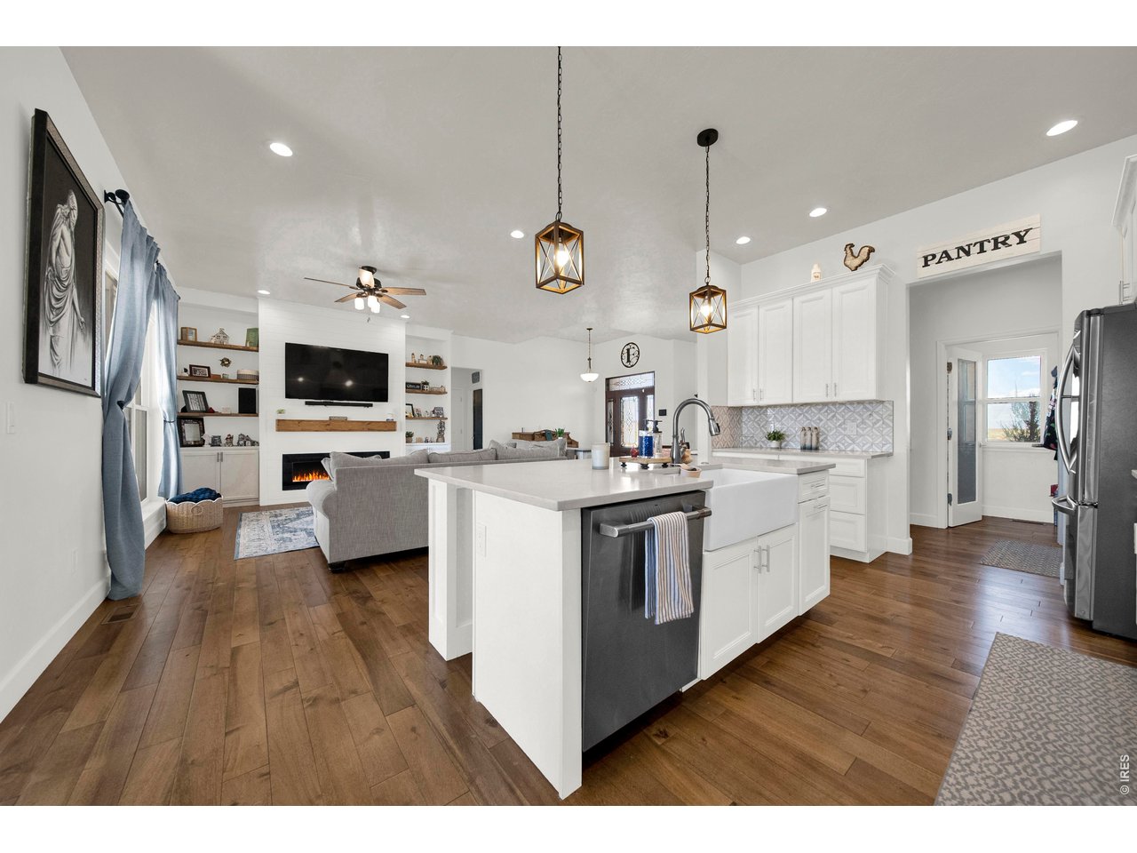 20138 State Highway 52, Unit 5 Fort Morgan, CO 80701 - Photo 49 of 50 a kitchen with stainless steel appliances kitchen island a white cabinets and wooden floor