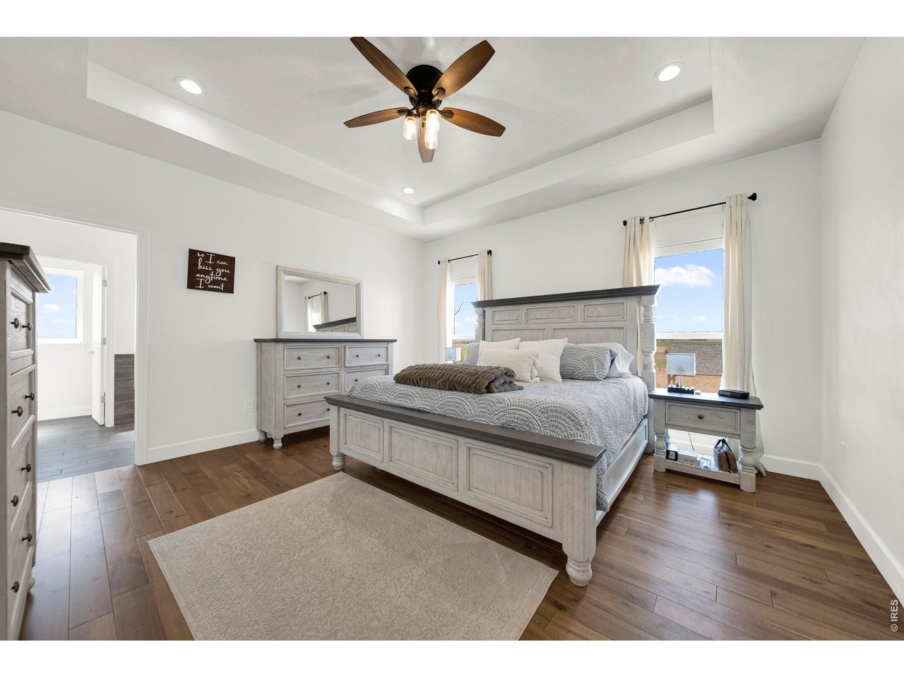 20138 State Highway 52, Unit 5 Fort Morgan, CO 80701 - Photo 19 of 50 a bedroom with a bed and a table with wooden floor
