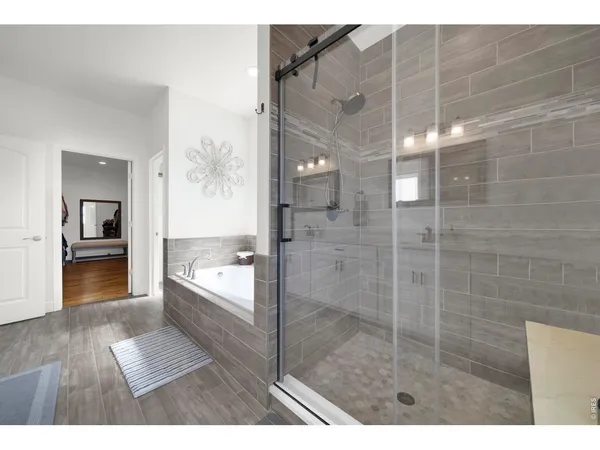 a en suite bathroom with a granite countertop sink and a large mirror