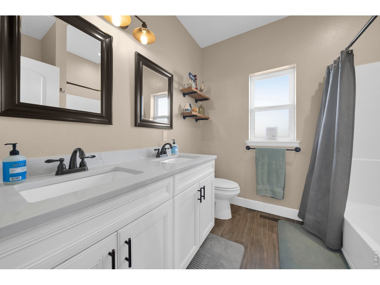 20138 State Highway 52, Unit 5 Fort Morgan, CO 80701 - Photo 27 of 50 a bathroom with a double vanity sink a toilet and a mirror
