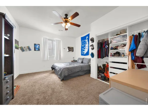 a spacious bedroom with a bed and ceiling fan