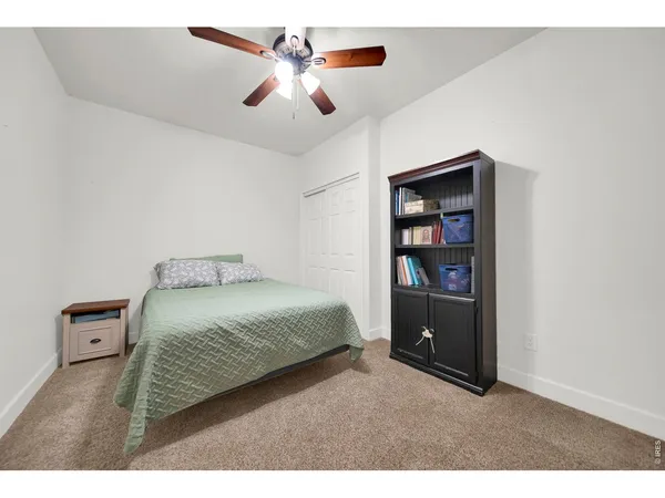 a bedroom with a bed and a book shelf