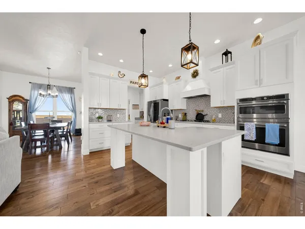a open kitchen with white cabinets and stainless steel appliances