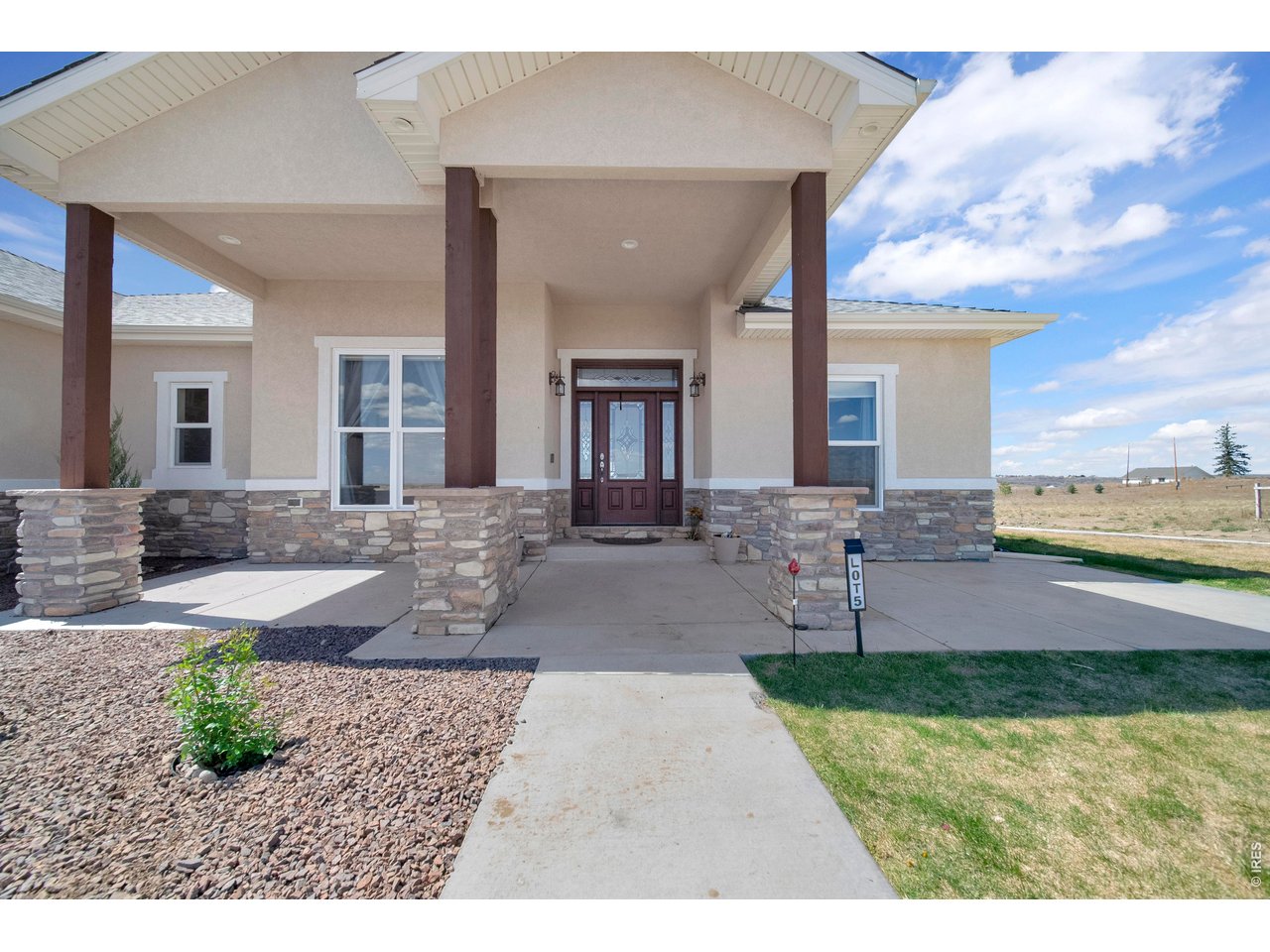 20138 State Highway 52, Unit 5 Fort Morgan, CO 80701 - Photo 45 of 50 a front view of a house with a yard and outdoor seating
