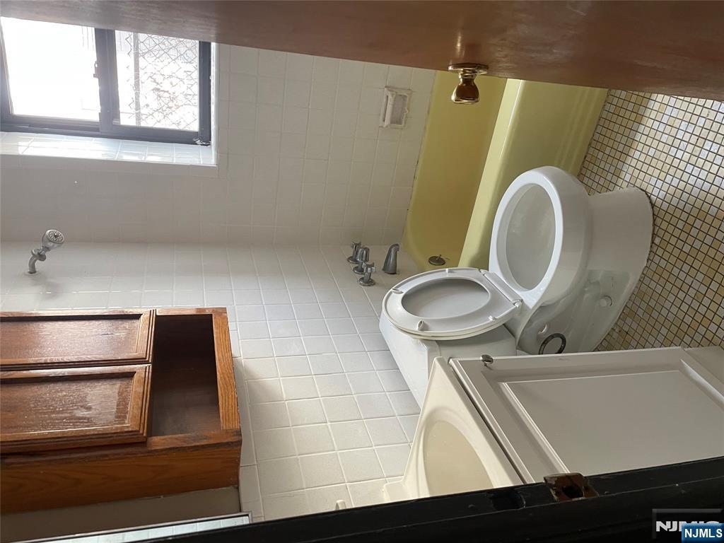 232-230 Anderson Avenue, Unit 1A Fairview, NJ 07022 - Photo 7 of 8 a bathroom with a toilet a sink and a window