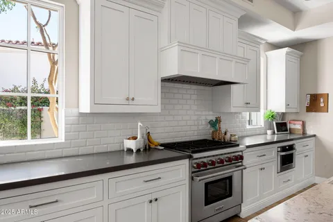 a kitchen with white cabinets and appliances