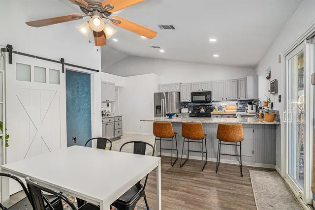 a living room with stainless steel appliances kitchen island granite countertop furniture and a refrigerator