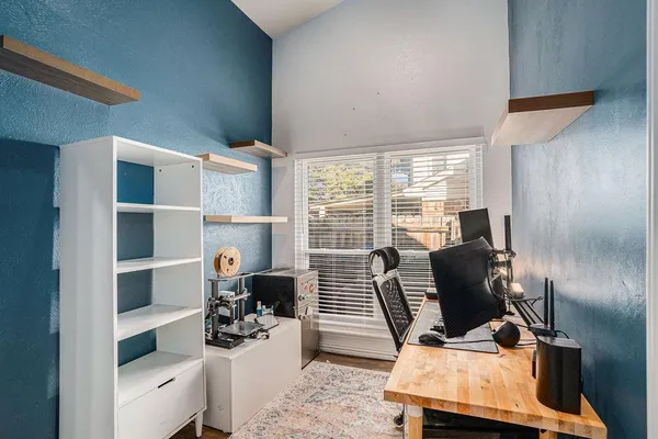 a view of a workspace with furniture and a window